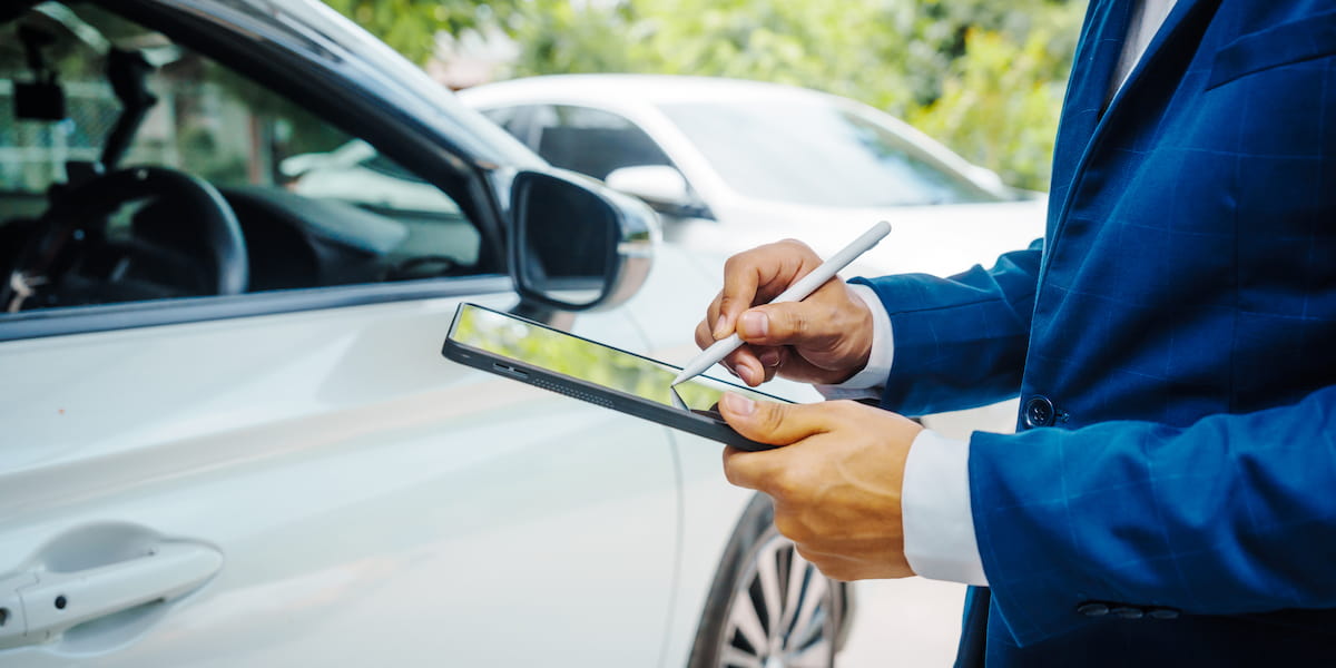 Insurance adjuster documenting vehicle damage after a crash showing types of car accidents and how they are evaluated