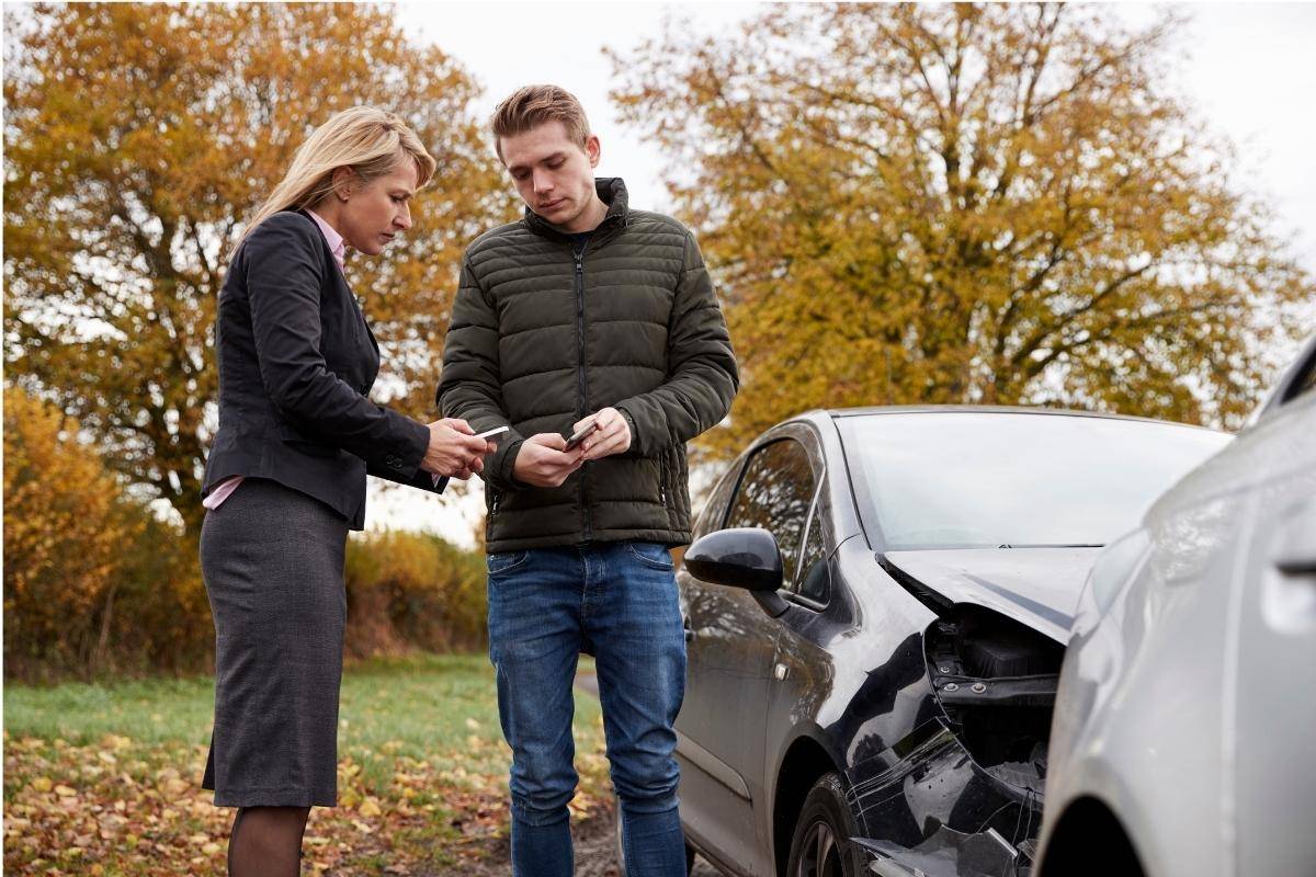 man and woman talking following a fender bender with two silver cars - florida car accident lawyers concept image