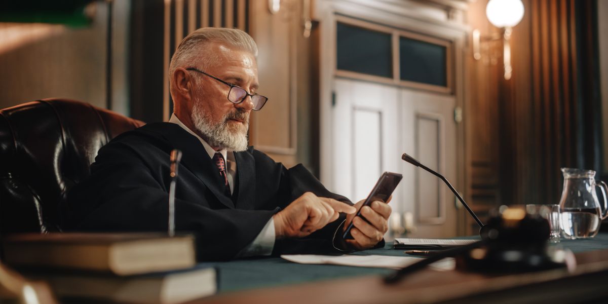 judge in court looking at social media on phone