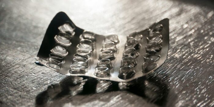 An empty blister pack of medication on a metal surface, symbolizing recalled drugs and the zantac cancer risk linked to long-term ranitidine use.